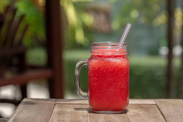 Fresh organic watermelon smoothie in glass mug on table, close up