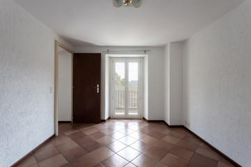 Front view of room with white walls and window looking nature
