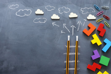 Education concept of Ladder made from pencils next to clouds over blackboard
