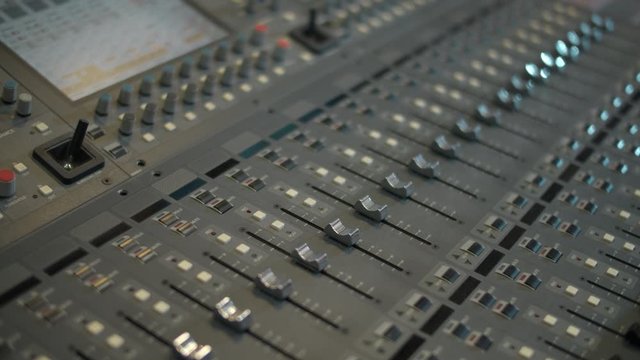 Close-up of a mixing console, automatic faders. Sound director works in the studio. Professional recording studio. Recording concept.