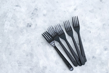 black plastic forks on a gray background