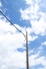 An electric post in a cloudy sky