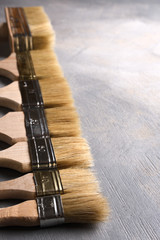 Brush for painting and spatulas on grey beton backdrop, background. Top view with copy space. Flat...