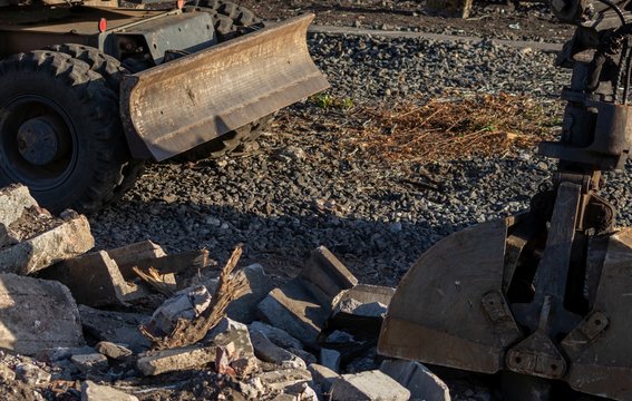 Mobilbagger mit Abst&uuml;tzplanierschild sorgt f&uuml;r Ordnung auf der Baustelle und beseitigt Schutt und Ger&ouml;ll durch viel PS neben Bahngleisen f&uuml;r Gleisarbeiten