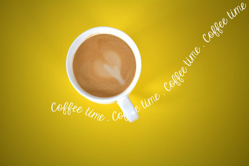 Yellow coffee from above - coffee time text running through cup