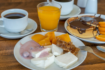 Breakfast of many dishes and drinks on a wooden table, closeup. Food concept