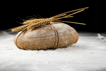 Front view of bread and wheat on flour
