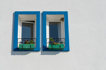 Two windows with flower pots on white wall in Bodrum, Turkey