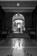 Games of the shadows and the light. The historical city center of Brescia, Italy street photography with biker going down from the stairs.