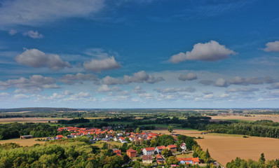 Aerial view of a blue sky with white clouds over a small village