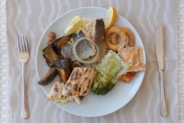 Various food on a white plate, closeup, top view