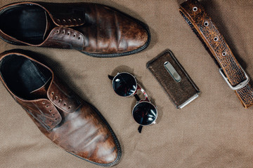 Brown leather retro shoes, belt, steampunk sunglasses and a pocket watch. Vintage style.