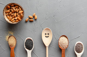 Superfood in spoons over gray concrete background