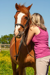 Obraz premium Portrait of a young girl and her pony having a hug, either in joy or sadness, no-one knows.