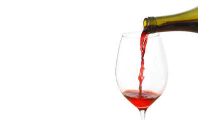 Pouring red wine into glass from bottle against white background