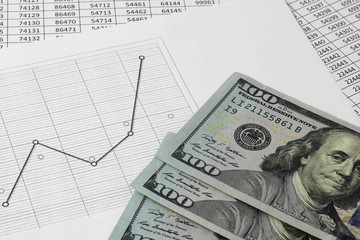 US dollars money lie on a table with a graph, and numbers. The concept of money saving and...