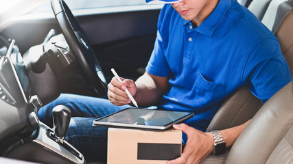 Delivery man checklist on tablet with sent package in side car.