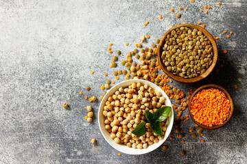 Healthy food, dieting, concept vegan protein source. Raw of legumes (chickpeas, red lentils, canadian lentils). Top view flat lay. Free space for your text.