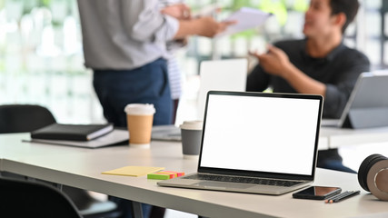 Laptop computer isolated screen on creative meeting table.