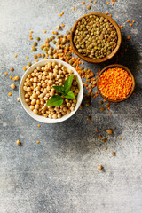 Healthy food, dieting, concept vegan protein source. Raw of legumes (chickpeas, red lentils, canadian lentils). Top view flat lay. Free space for your text.