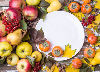 Naklejka na ściany i meble Ceramic plate with autumn fruits and leaves.