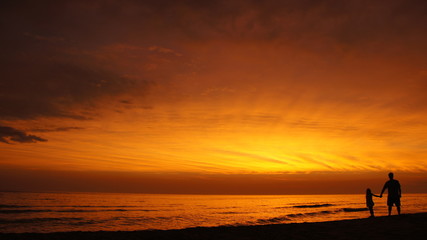 Fototapeta premium Father & Daughter Silhouetted by Lake Michigan Sunset, Gray Dunes, Muskegon County, Michigan