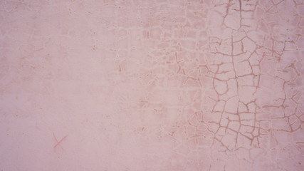 pink plaster wall in cracks and stains