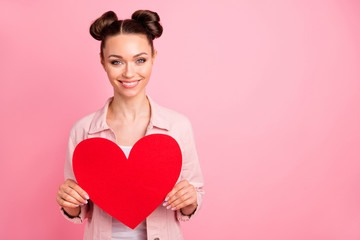 Portrait of charming lady holding papercard heart smiling wearing jacket isolated over pink background