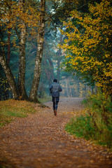 Photo from back of running athlete in autumn park