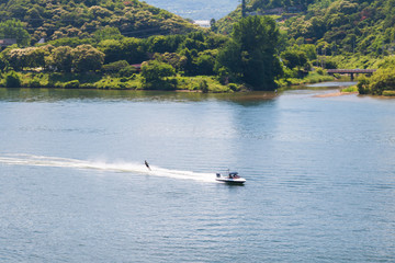 Obraz premium Aerial view photo of high speed water ski towed by speed boat in river