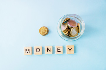 the future of Finance, business banking and financial concept. Flatlay Euro cents and cubic letters money glass jar on blue color background. Selective focus