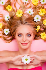 Obraz na płótnie Canvas Vertical top above high angle view photo beautiful she her lady lying down among flowers long curly wavy hair one in arms floral skin treatment overjoyed relaxing isolated pink background