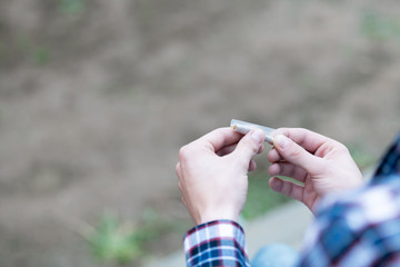Two hands rolling a cigarette with a selective focus.
