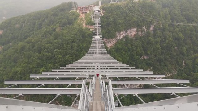 Sochi, Russia - may 2019. Suspension bridge in Sochi Skypark, man walking on bridge. Camera move up