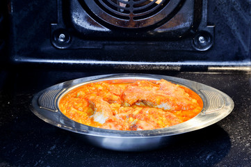 Sea bass is baked in the oven in a sauce with vegetables. Diet concept