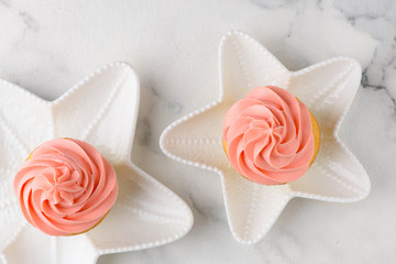 two pink cupcakes on star plates