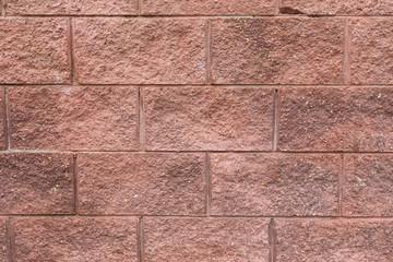 Grunge red brickwork on building wall surface, close-up of dicorative tiles