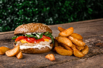 cheeseburger with chicken meat fries on a wooden board