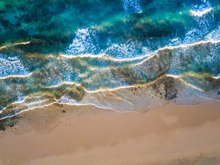 Above vertical view of blue ocean waves and yellow sandy beach - summer holiday vacation concept - travel and scenic place - energy nature outdoors with nobody there