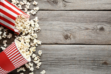 Popcorn in striped buckets on wooden table