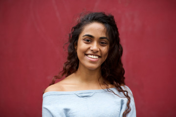 Obraz premium front portrait of beautiful young Indian woman with happy expression against red background