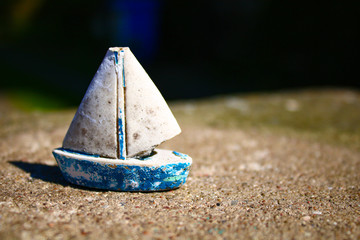 Fototapeta na wymiar Toy boat on stony ground