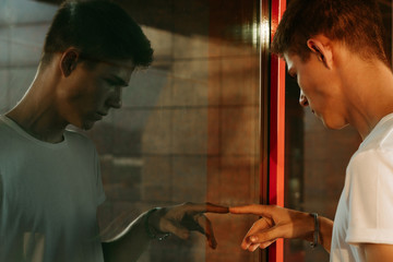 Portrait of a guy in a white T-shirt. Window reflection
