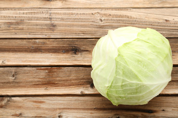 Ripe cabbage on brown wooden table