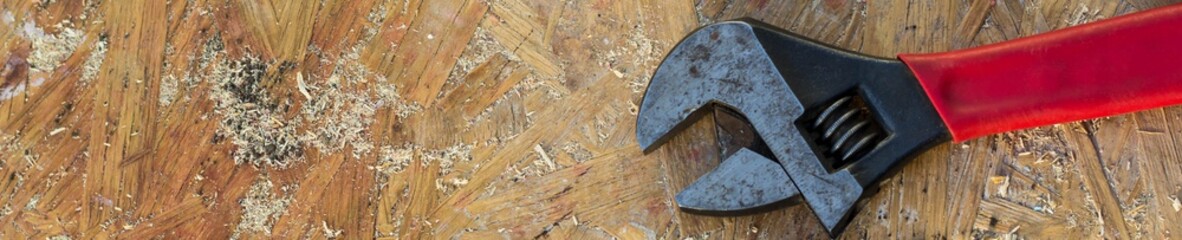 banner of adjustable wrench, spanner tools on wooden table