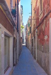 Obraz na płótnie Canvas Narrow street with historic houses in Venice, Italy, in a beautiful sunny day.