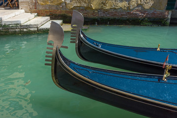Fototapeta na wymiar Venice, Italy. Close up of a two gondolas and the blue water of a Venetian canal, in a beautiful sunny day.