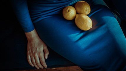 Photo of seating woman in blu dress. Yellow lemons on background. Color background wallpapers