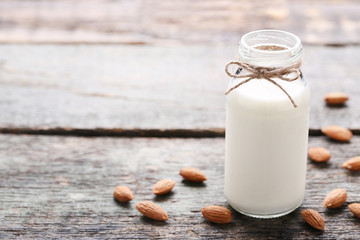 Almond milk in bottle on grey wooden table