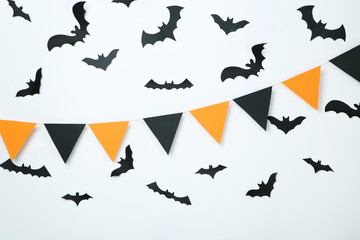 Naklejka premium Paper halloween bats and flags on white background